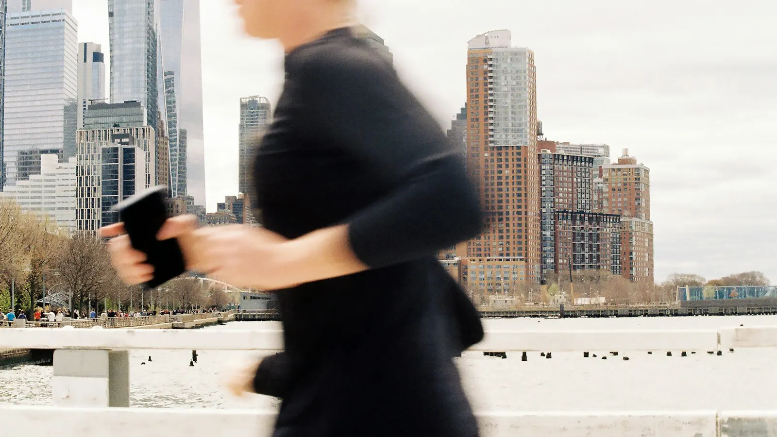 Corredor usando aplicativo de corrida no celular para rastrear treino ao ar livre